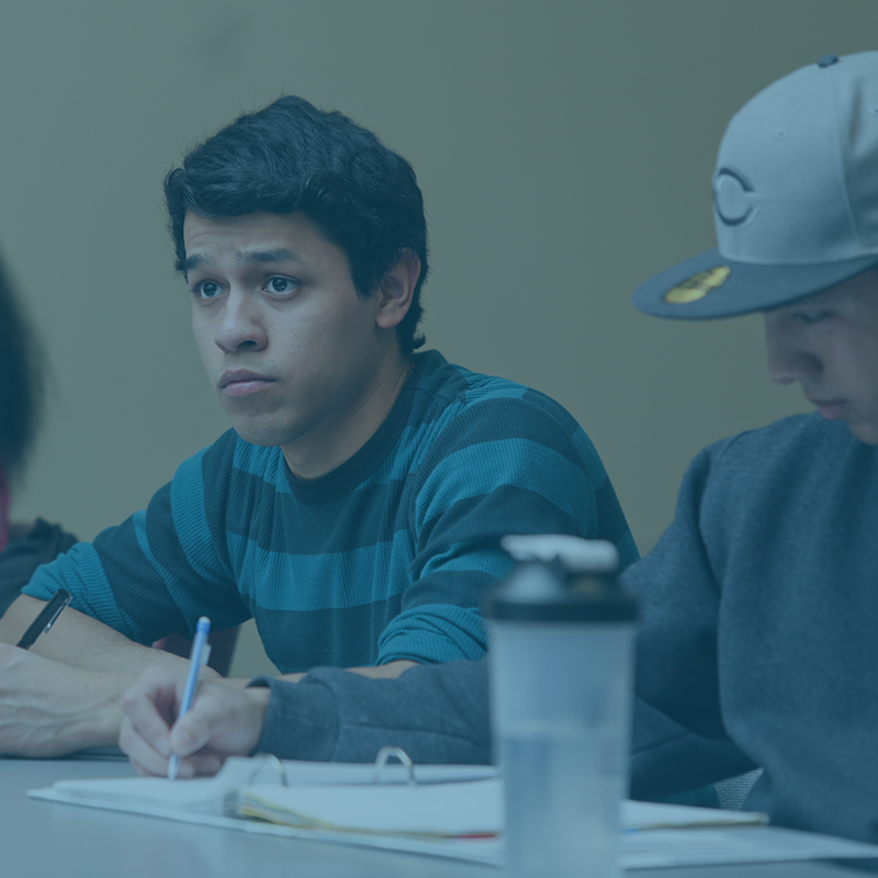Woman working at a desk with laptop and writing